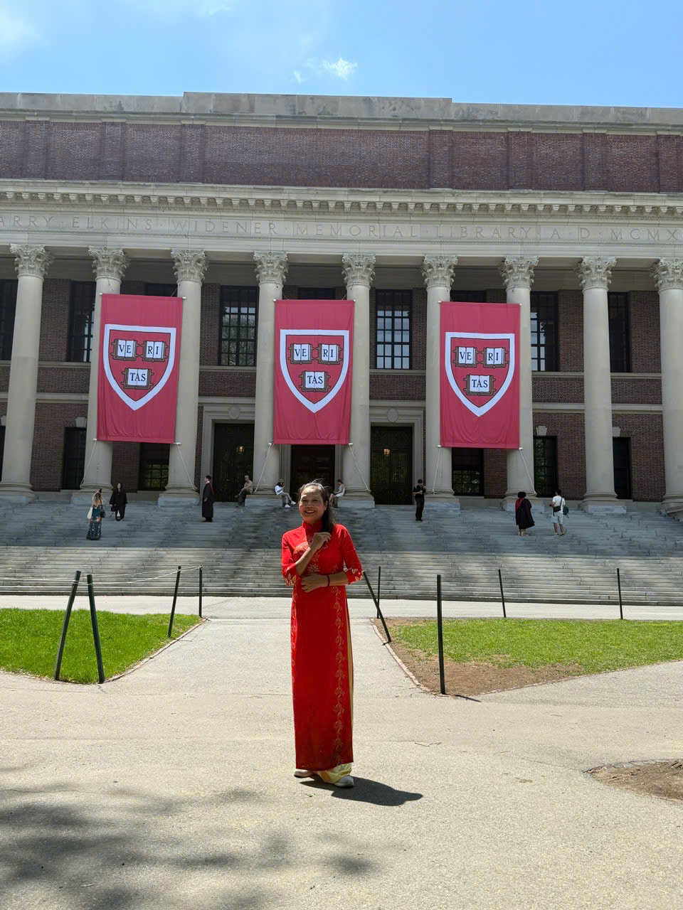 Cô Liên mặc áo dài đỏ trước thư viện Widener trong chuyến thăm Harvard